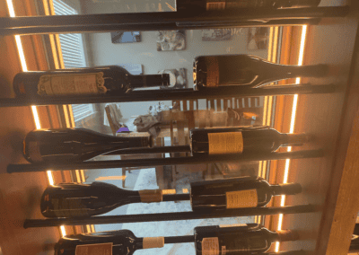 Collection of wine bottles displayed on a wooden rack at Example Co.