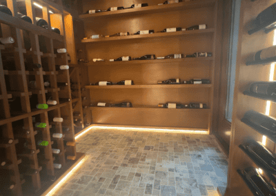 Elegant wine cellar with wooden racks and ambient lighting showcasing wine bottles.