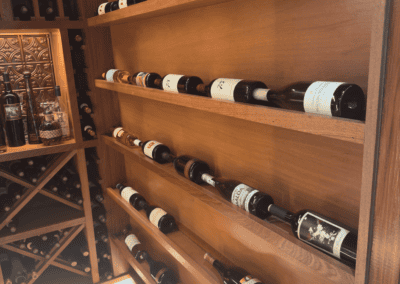 Wooden wine rack with various wine bottles in a wine shop or cellar setting.