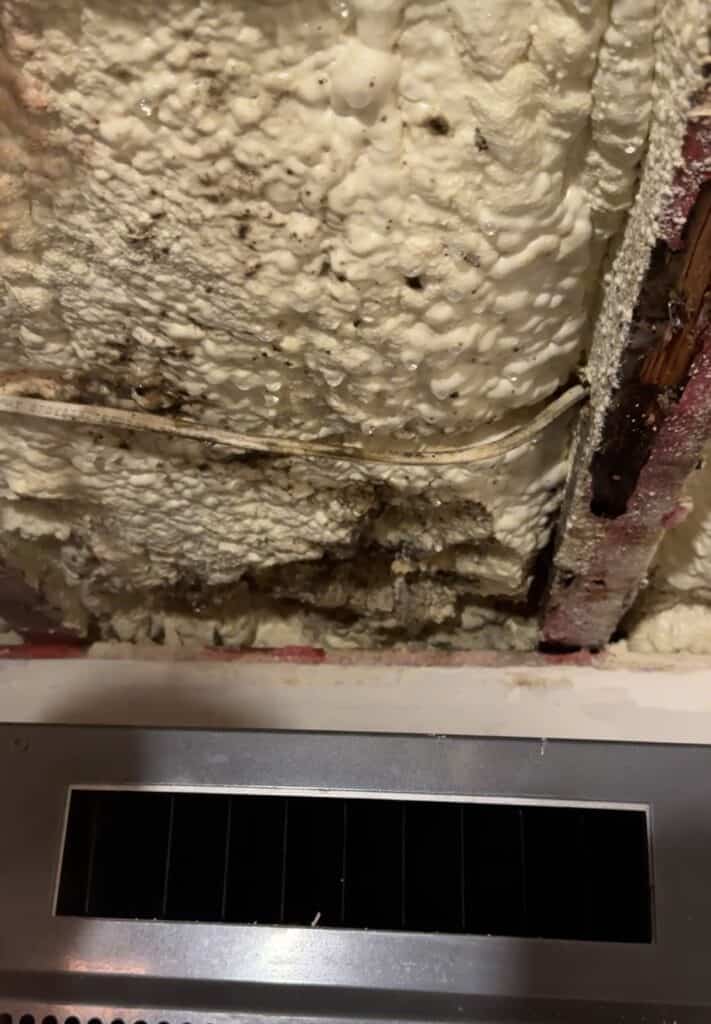 Wine cellar cooling unit mounted below a wall cavity with condensation on the insulation