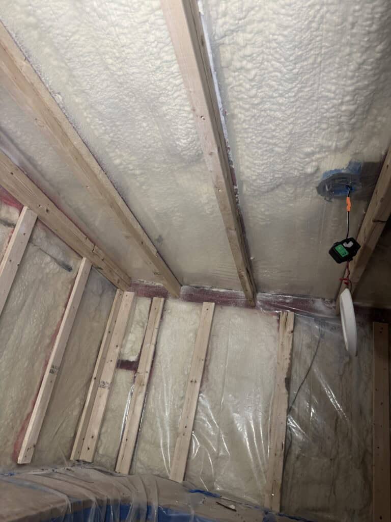 New wine cellar framing built over a plastic vapor barrier during a mold rebuild
